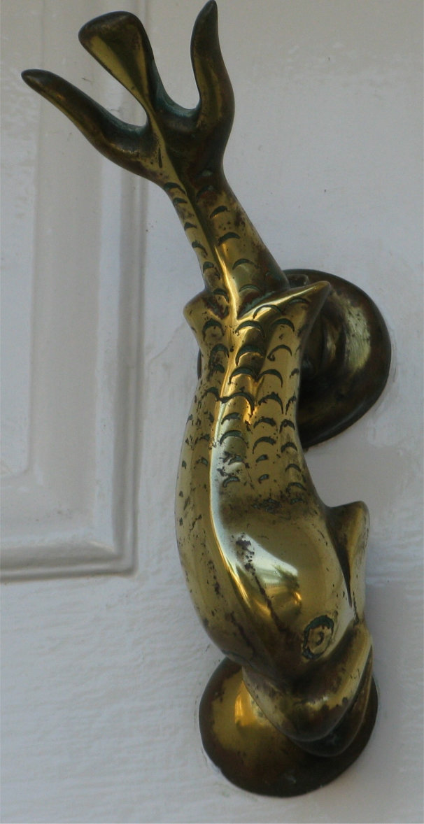 Brass knocker in form of fish, tail top, head bottom
