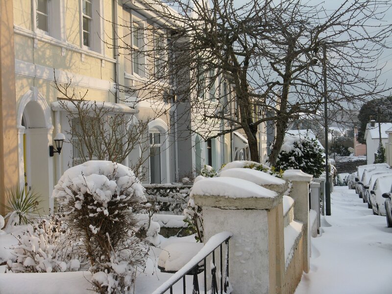 Street o terrac houses and cars undr recent snowfall