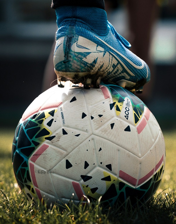 Boot on top of football